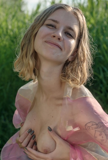 Thin teen Artemida plays with her tits and nipples while naked amid long grass 48819309
