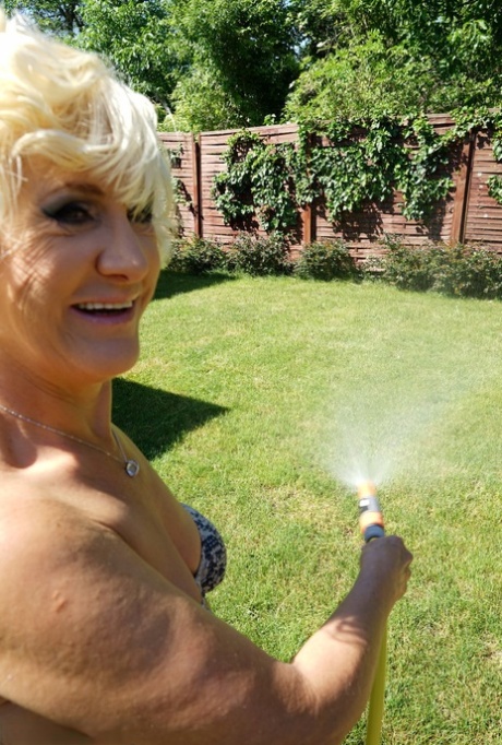 Mature blonde woman takes off her bikini while wandering around her property 76110865