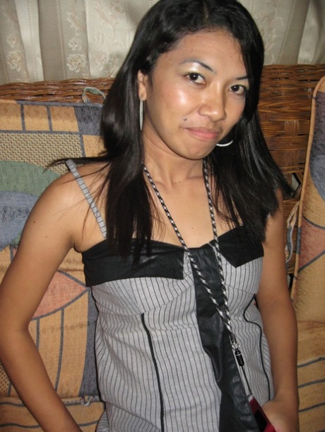 Young Pinay girl in a Nike baseball cap takes off her clothing on a loveseat 18923507